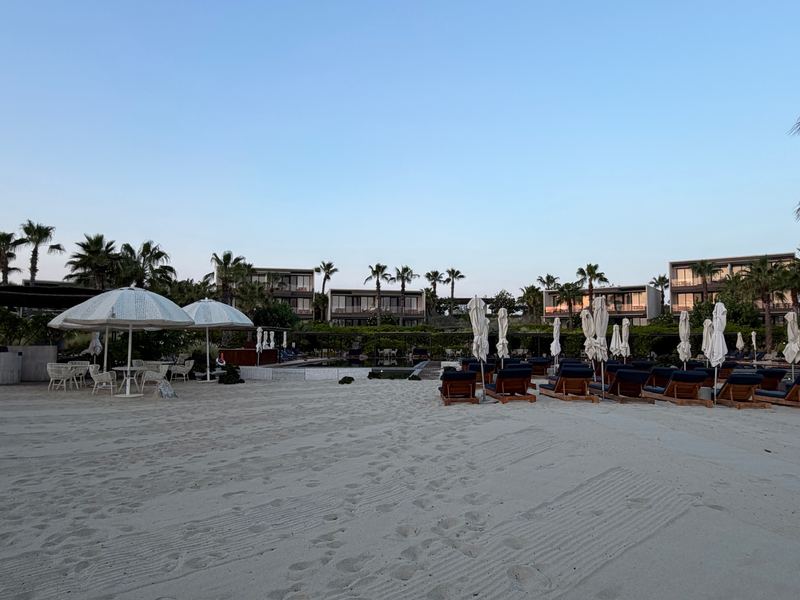 The beach at dusk, villas behind the dunes.
