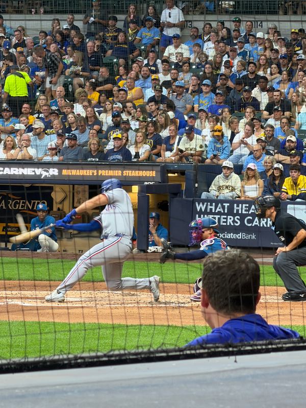 A batter swings at American Family Field, the crowd behind