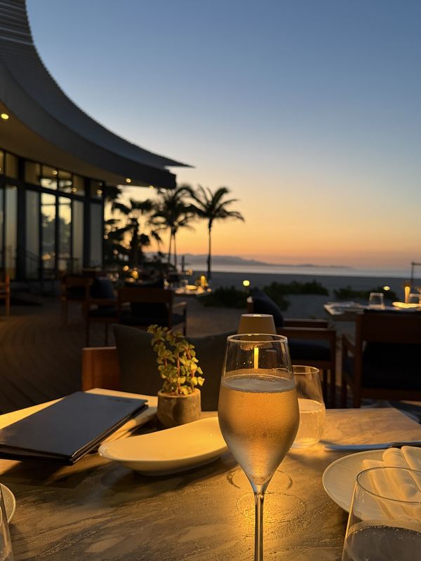 Champagne on a beachfront table at dusk at Estiatorio Milos