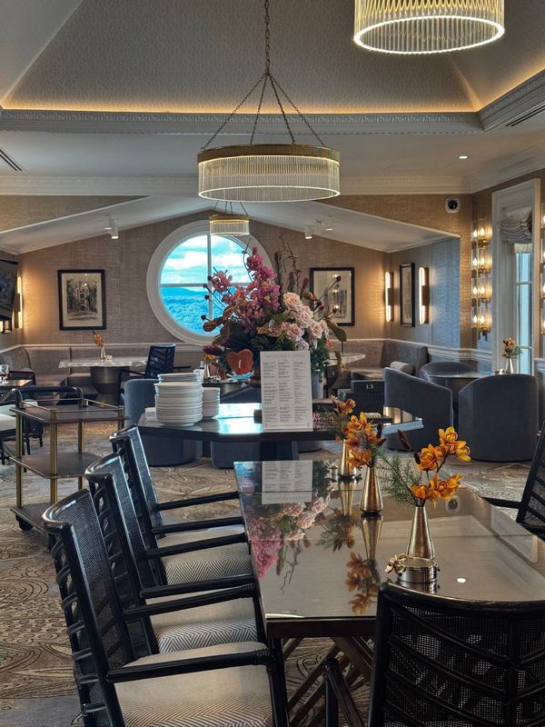 The concierge level club in the Chateau: dark chairs, a vase of flowers and a chandelier