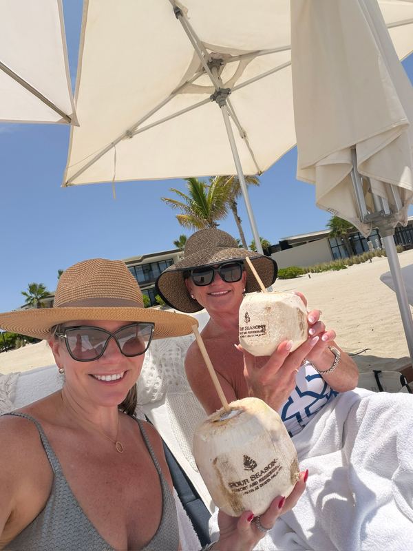 Jeannie and family with coconuts under the white umbrellas on the beach