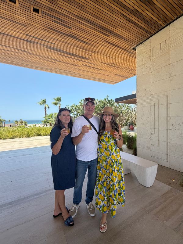 Steve, Jeannie and family under the breezeway with welcome drinks, the sea behind