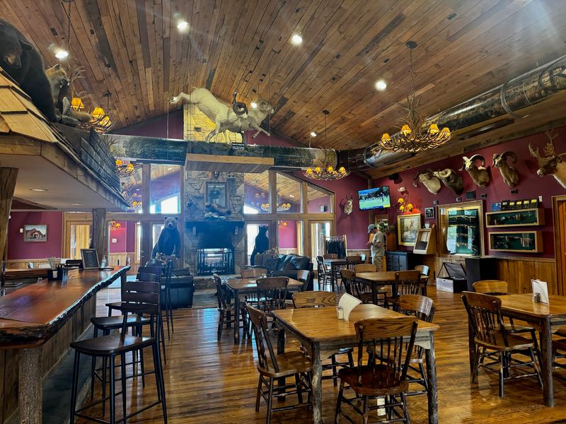 The timber lodge at the Field Club, animal mounts on the walls, tables and a bar
