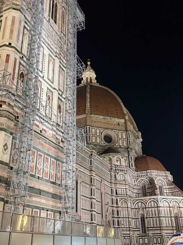 Giotto's campanile under scaffolding beside the Duomo, at night