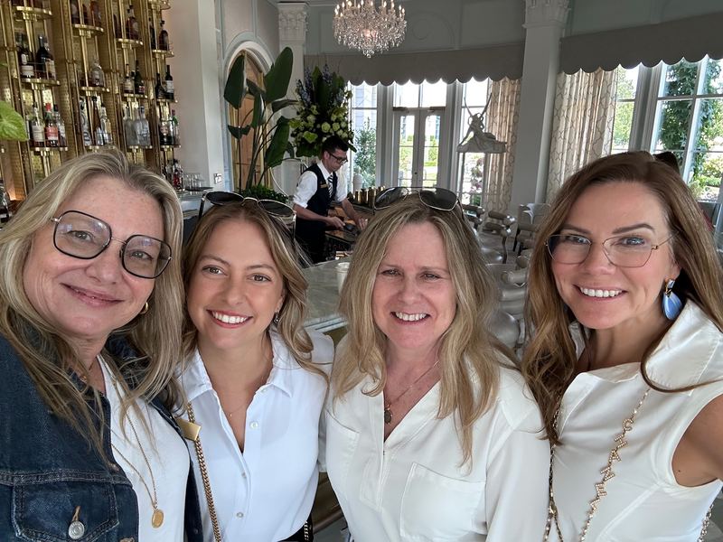 The Harvell Travel team and their Nemacolin host Laura, four women smiling for a selfie in the Lobby Bar