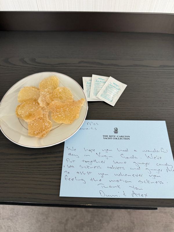 A plate of ginger candies beside a handwritten card from the crew on a dark table