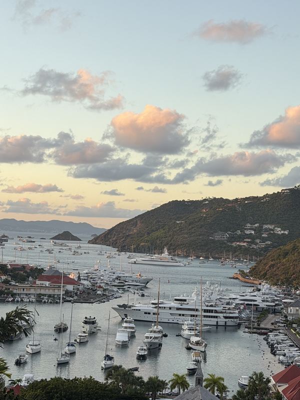 Gustavia harbour at dusk, yachts along the quay under a pink sky