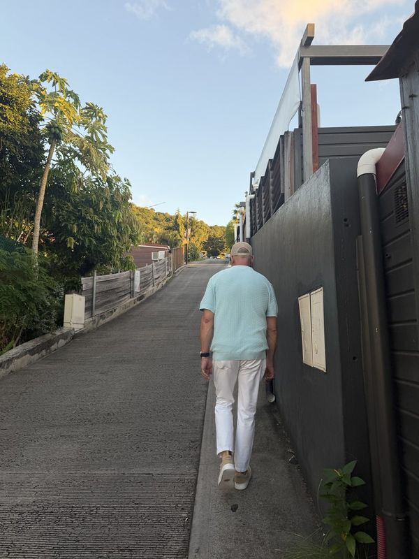 A narrow Gustavia lane in late afternoon light, walls and greenery on both sides