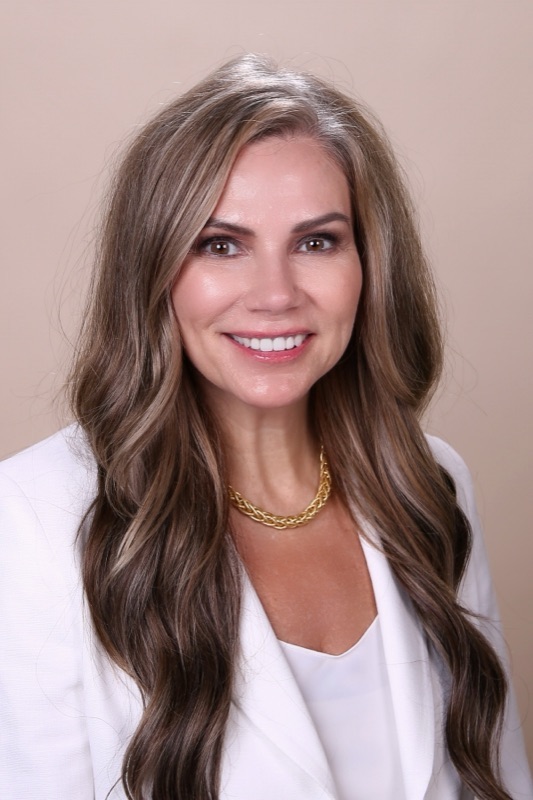 Jeannie Zemaitis, travel advisor, in a white blazer against a soft neutral backdrop