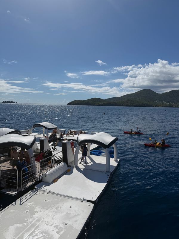 The marina platform at the ship's stern with kayaks on the water and the island behind