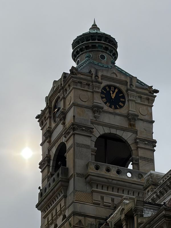 A downtown clock tower against a white sky
