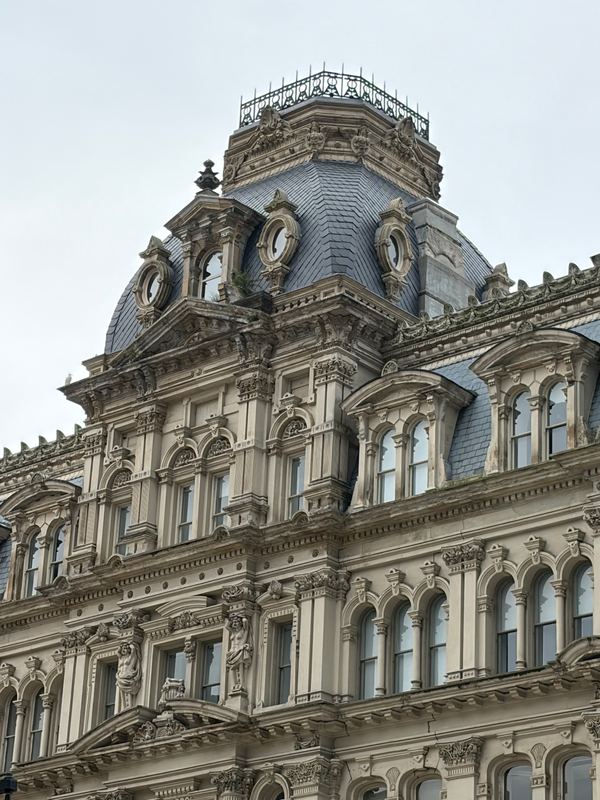 The mansard roof and clock faces of a nineteenth-century downtown block