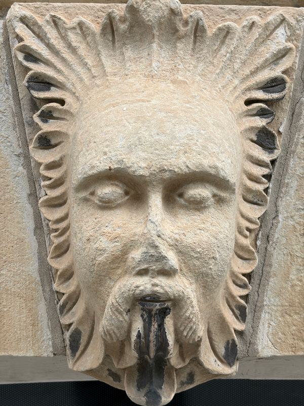 A carved stone face on a downtown facade