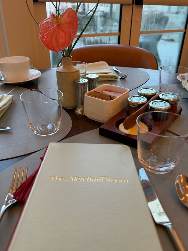 The Merchant Room menu at the table, an anthurium in the vase