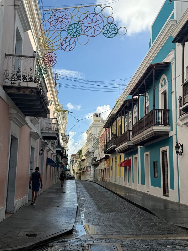 A painted street in Old San Juan with decorations strung overhead