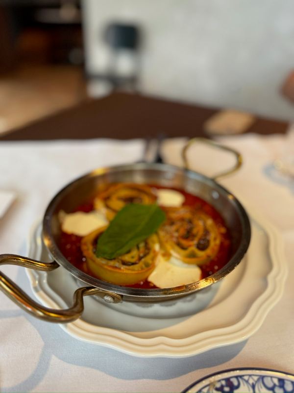 Pasta in tomato sauce with mozzarella and basil, served in a small copper pan