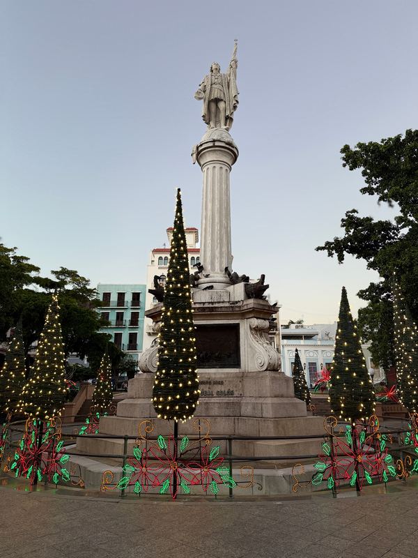 The Columbus monument on Plaza Colón, ringed with lit trees
