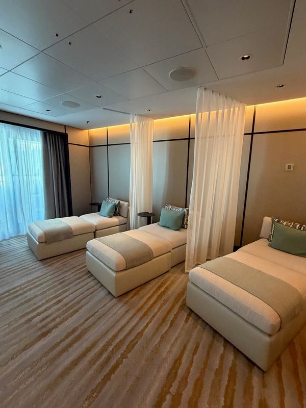 Cushioned loungers behind sheer curtains in the ship's spa relaxation room