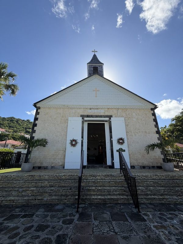 The white parish church of Gustavia with its bell tower against a deep blue sky
