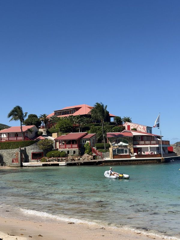 St. Jean Bay from the sand, red-roofed buildings on the point across the shallow turquoise water