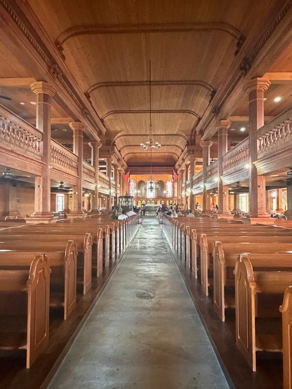 The wooden interior of the cathedral in St. John's: pews, columns and a gallery all in polished wood