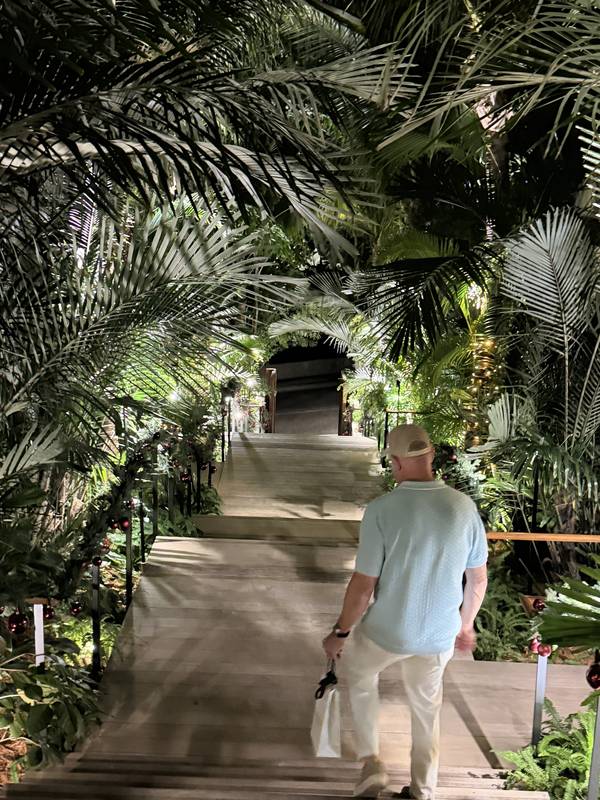 Steve walking up a lit stairway between palms at night at Fouquet's Saint-Barth, Gustavia