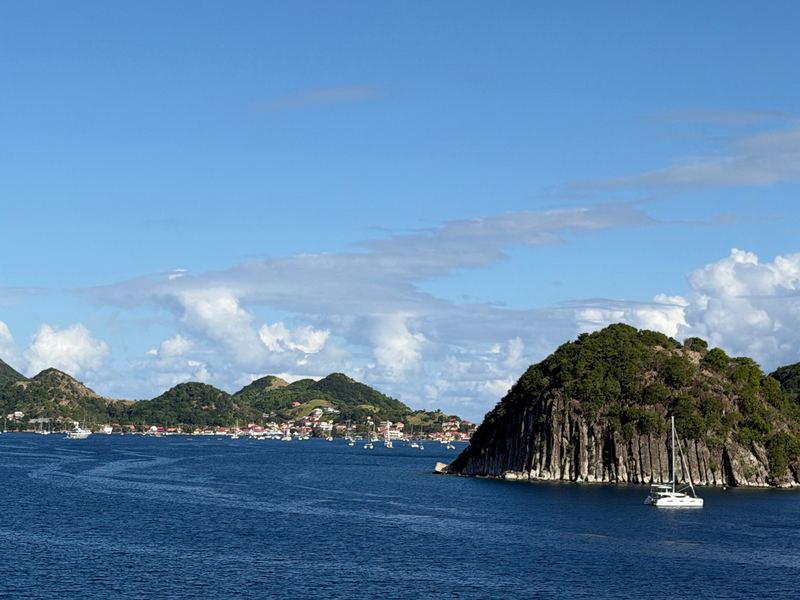 Terre-de-Haut across the bay: red roofs along the shore and a rocky headland, boats at anchor