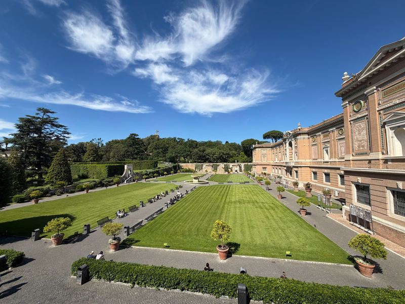 The lawn of the Vatican Museums' gardens under a streaked sky