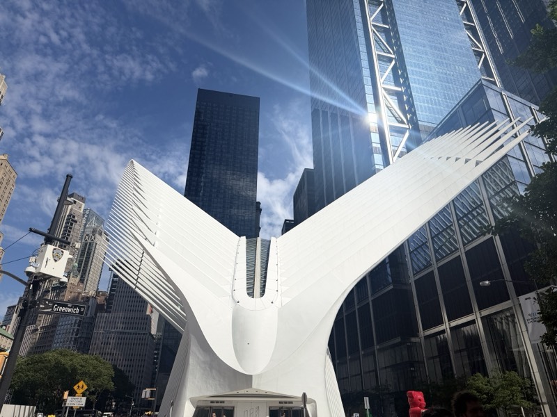 White station building with a covered platform wing under an open sky