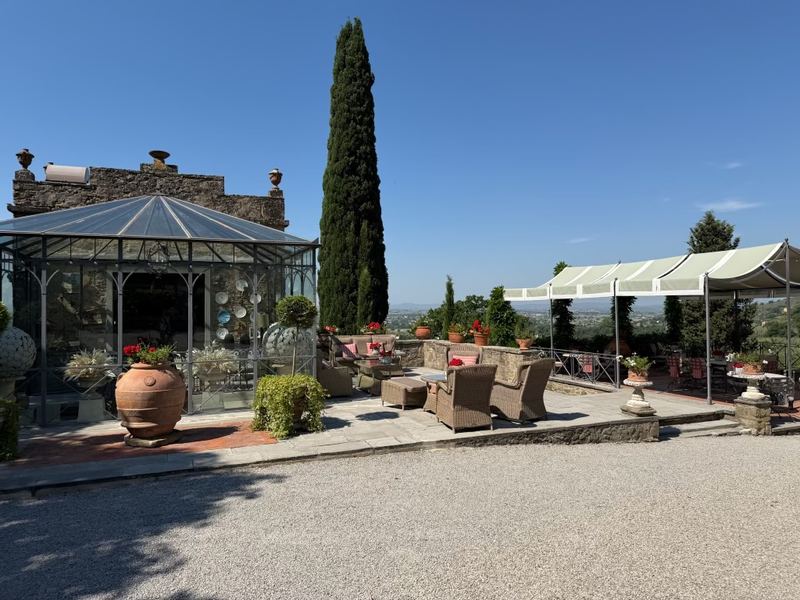 The terrace at the winery, with its glasshouse and a single cypress