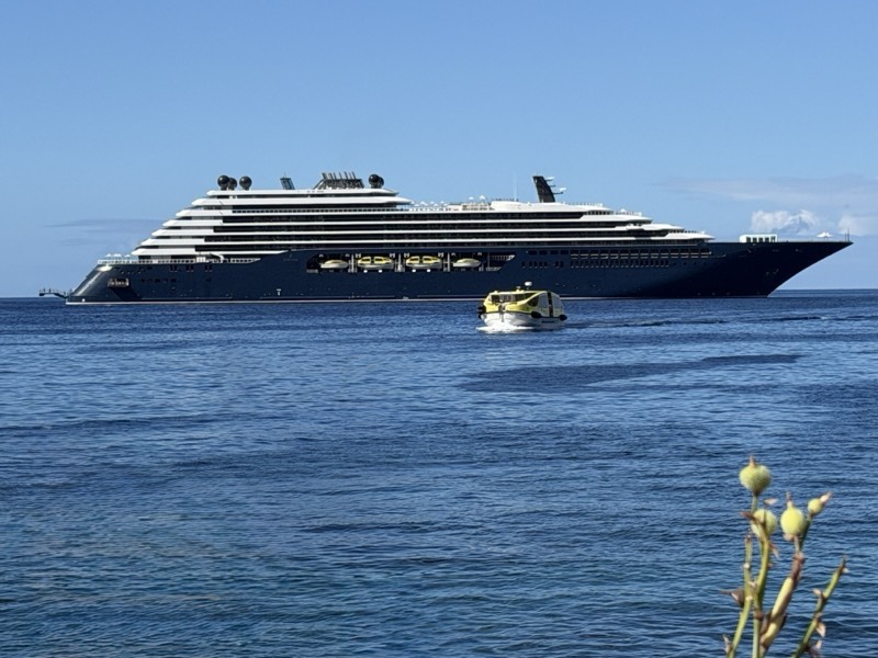 Ilma at anchor off Soufrière, St. Lucia, a tender running past under a blue sky